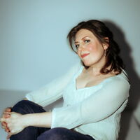 Elena Gaponenko in heller Bluse vor hellblauem Hintergrund